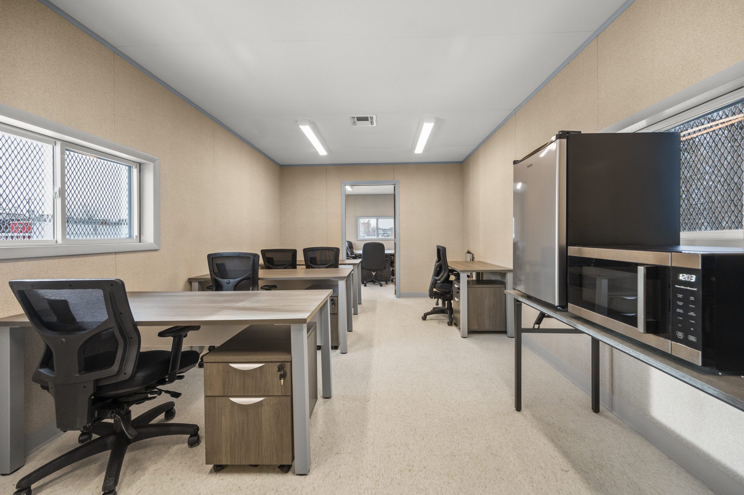 Office workspace with desks, chairs, and office equipment in a modular office unit.